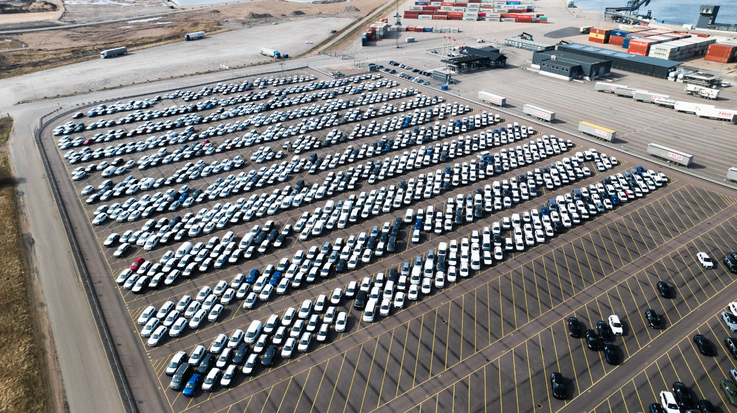 Nya bilar parkerade på rad i hamn